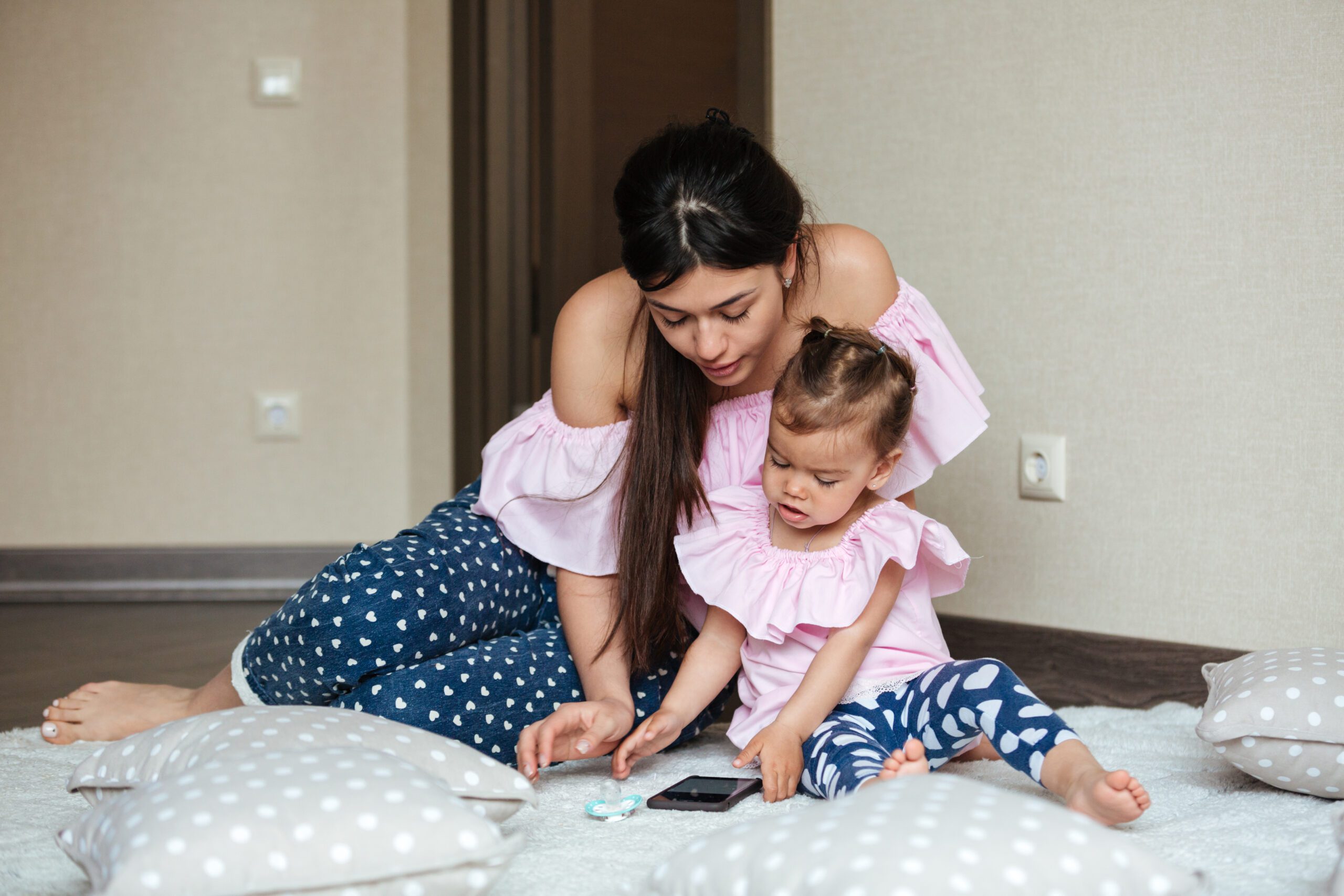 image of concentrated young mother with her little daughter lies on bed indoors and ch SBI 321514146 scaled